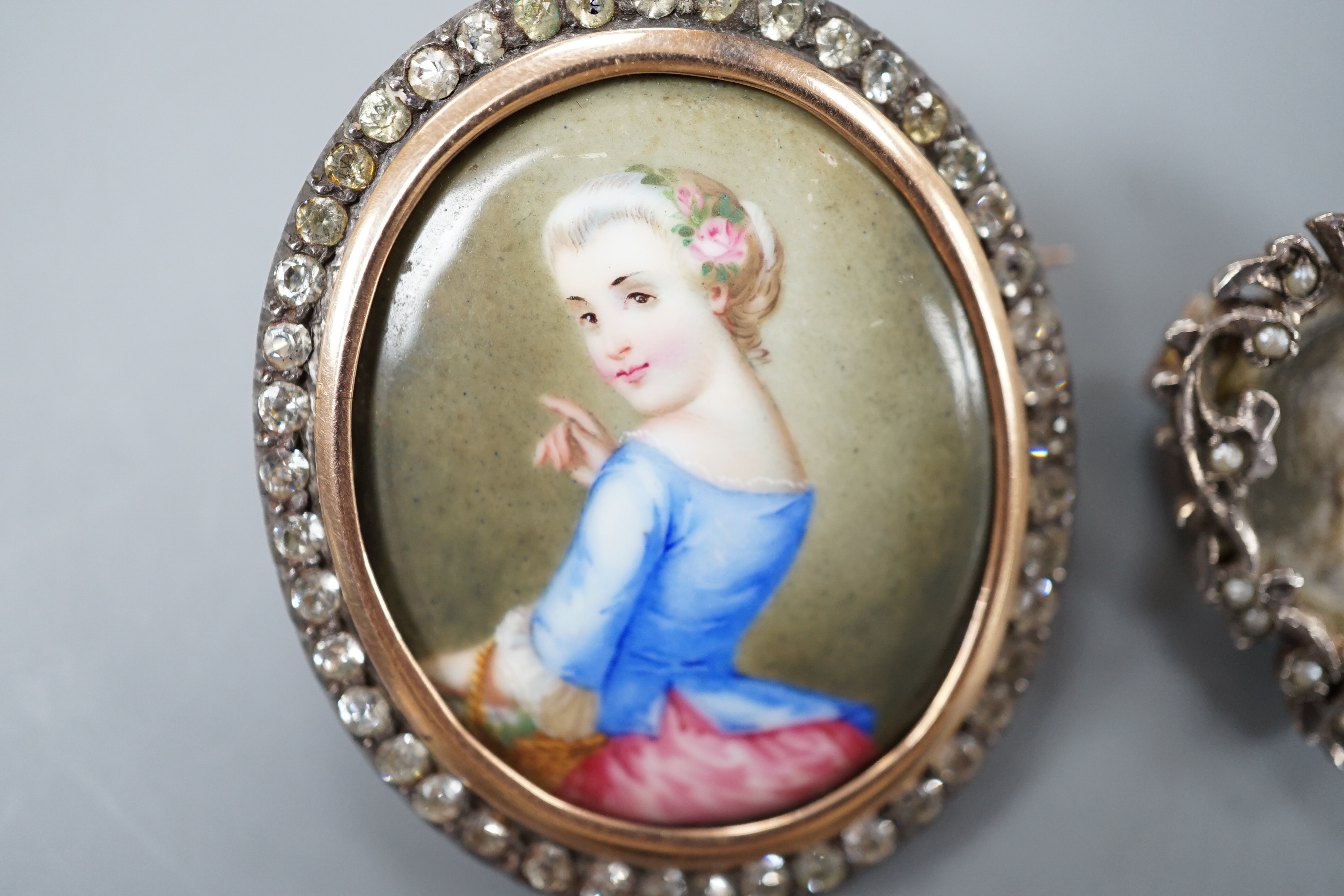 A Victorian yellow and white metal and paste set oval miniature brooch, 41mm and a small circular seed pearl set miniature brooch.